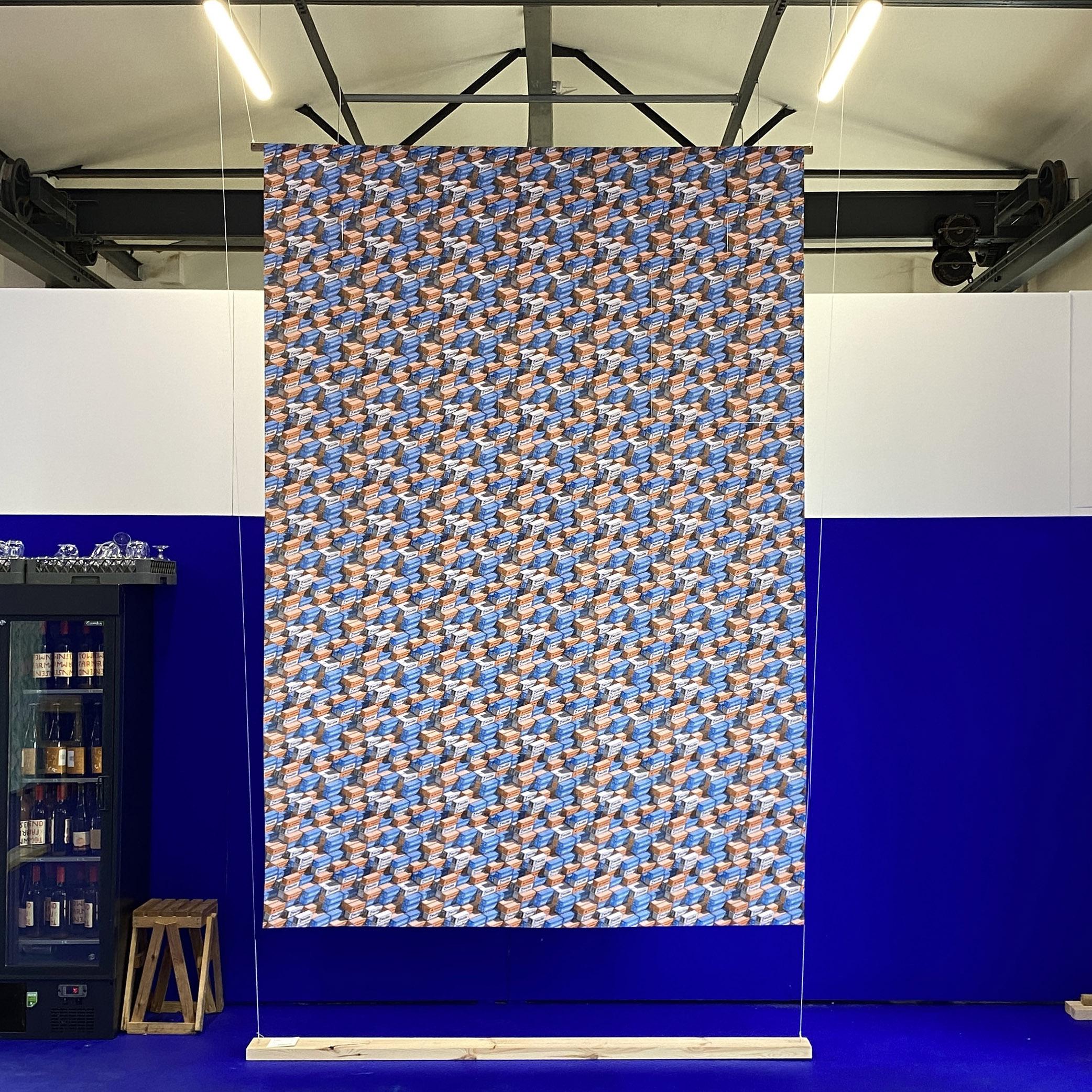 A physical pattern about shipping containers on display in a blue walled industrial unit